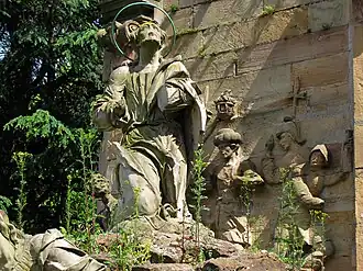 Le monument envahi par les plantes, détail du Christ et des soldats.