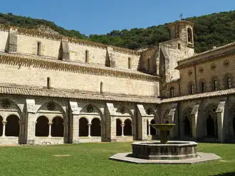 Photographie d'un cloître gothique d'abbaye.