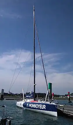 Vue de trois quarts avant, voilier bleu et blanc amarré au ponton.