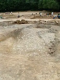 Photo en couleurs d'une zone empierrée creusée de deux rainures parallèles.