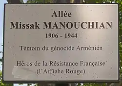 Photographie du panneau de l'allée Missak Manouchian de Montpellier disant « Témoin du génocide Arménien. Héros de la Résistance française et membre du groupe de l'Affiche rouge ».