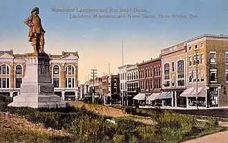 Statue de Laviolette (érigée en 1884 lors des célébrations du 250e de la ville et disparue en 1919) et vue sur la rue Notre-Dame-Centre, à Trois-Rivières vers 1900.