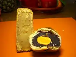 Gâteaux coupés en deux, à gauche au rhizome de lotus, à droite à la purée de haricots rouges et au jaune d'œuf.