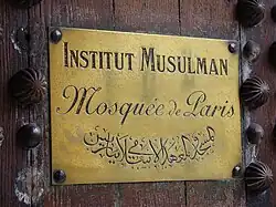 Plaque sur la porte de l'entrée principale.