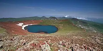 Vue du lac de cratère de l'Ajdahak avec d'autres sommets volcaniques du massif de Gegham en arrière-plan.