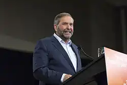 Thomas Mulcair à Ottawa derrière un pupitre aux couleurs du NPD