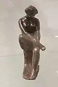 Statuette de femme assise jambe repliée, 1900.