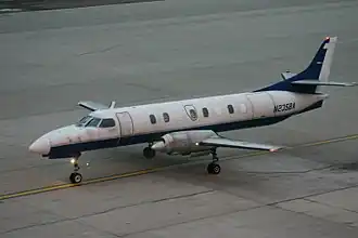 Photographie d'un avion bimoteur à hélices au sol.