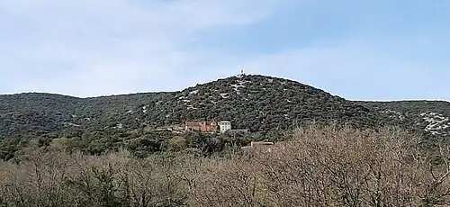 Vue de loin, le sanctuaire et la statue en haut de la colline.