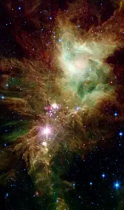 NGC 2264 en infrarouge par le télescope spatial Spitzer. En rose, des étoiles nouvellement formées. On a donné le nom d'amas du Flocon de Neige&nbsp;(en) au groupe d'étoiles que l'on voit sur cette photo.