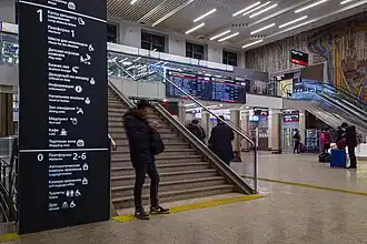 Panneaux d'information et panneaux dans le hall de la gare.