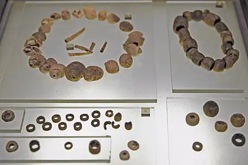 Coquillages perforés, perles de calcaire et de variscite. Tumulus A, niveau supérieur, IVe&nbsp;millénaire.