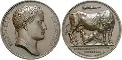  Les deux vues, avers et revers d'une médaille. À gauche le profil de Napoléon, à droite une vache allaitée