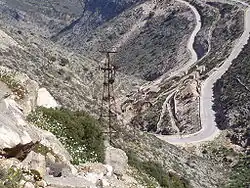 photographie : paysage sec de montagne avec un pylône rouillé