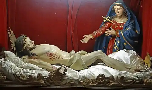 Gisant avec la Vierge dont le flanc est percé par un poignard.