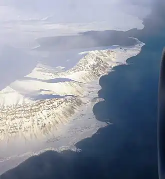 Premier plan : les montagnes d'Ingeborgfjellet et Sundhögda. On aperçoit bien la presqu'île d'Hamnodden et la baie qui est libre de glace.