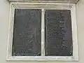 Deux plaques en ancien français sur la façade de l'église.