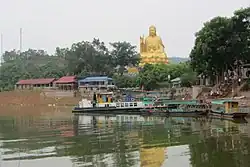 Statue de Bouddha et bateaux d'excursion au lac Nui Coc.