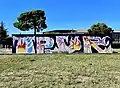 Graffiti de OPUR, pièce picturale s'intégrant dans le street art par le mélange de lettres et de motifs colorés.