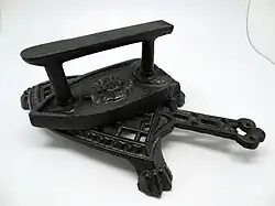 Fer à repasser en fonte sur son support