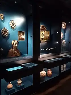 Vitrines avec des figures pieuses, des céramiques (jarres, vases, pichets) et monnaies espagnoles.