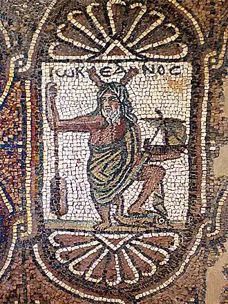Représentation d'Océan, surmonté de son nom grec Ὠκεανός&nbsp;/ Ōkeanós (écrit ωΚΕΑΝΟϹ), avec ses attributs habituels : pinces de crustacé sur la tête et rame à la main, auxquels ont été rajoutés ici un navire et un dauphin. Église byzantine de Pétra (Jordanie), aile sud, mosaïque (VIe&nbsp;siècle).