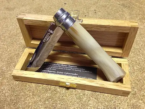 Un couteau ouvert à moitié dans un boite en bois