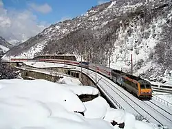 Double traction avec deux BB 26000 tractant un train Copenhague - Modane dans un décors montagneux et enneigé
