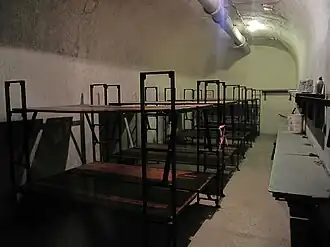 Les travées de la caserne sont aménagées en chambres pour la troupe, deux hommes se partageant la même couchette.