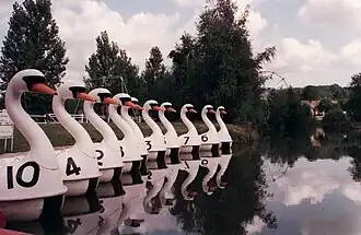 Photographie d'un bassin avec des petits bateaux en forme de cygne.