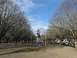 2 rangées d'arbres alignés de part et d'autre d'une large allée, avec au centre le monument aux morts.