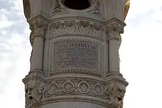 Inscription : Georges SAUMANDE MAIRE / Charles SEGARD Colonel en retraite / Commandeur de la Légion d'honneur / Premier adjoint / Edmond LACOUT Conseiller / municipal délégué aux fonctions de / deuxième adjoint, sur un côté du piédestal de la statue, fontaine de la place Plumancy.