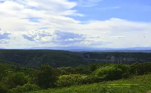 Nous sommes sur le terrain militaire en zone protégée. Au fond la Lozère et ses chaînes de montagnes à 80&nbsp;km. En premier plan, les falaises du Gardon sur la commune de Sanilhac.