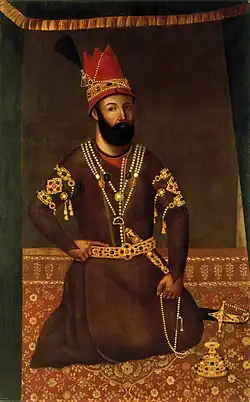Portrait d'homme, barbu, accroupi, en habits orientaux.