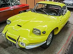 Photo d'un coupé sportif jaune exposée dans un musée.