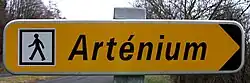 Panneau directionnel D29 (Arténium) avec idéogramme ID34a (itinéraire piétonnier)