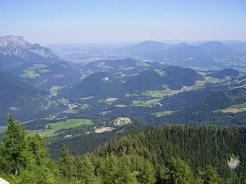 Panorama vers le nord, depuis la route qui mène au « Nid d’aigle » (Kehlsteinhaus). Salzbourg est à peine visible au fond. Berchtesgaden se trouve juste sur la gauche en dehors du cadre. Le Kempinski Hotel&nbsp;(de) est au centre, au pied de la montagne.