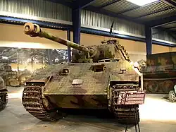 Photographie prise dans un musée et montrant de face un char Panther A peint en camouflage et couvert d’un revêtement granuleux.