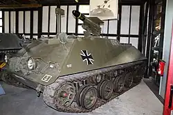 Photo couleur d'un véhicule blindé dans un musée, avec un lance-missile sur le dessus du véhicule.