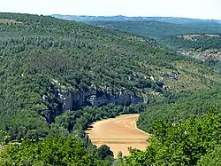 Paysage des Causses du Quercy : collines recouvertes de pelouse calcaire et de forêt méditerranéenne, terres agricoles en vallée.