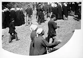 Mendiants lors du Pardon de Saint-Jean-du-Doigt photographié par Charles Géniaux entre 1902 et 1905. Les femmes portent la toukenn, coiffe emblématique du Trégor.