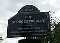 Plaque de rue à Paris, avec l’odonyme simplifié « rue Georges-Picquart ».