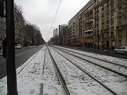 Le boulevard Brune en 2010, sous la neige, avec un tramway de la ligne T3, selon sa dénomination d'alors, circulant sur une plateforme réservée à son usage.