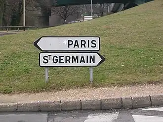 Sur une route, deux panneaux directionnels indiquent les villes de Paris et de Saint-Germain