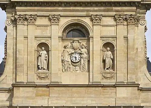 Détail de la façade. À gauche, la statue de Saint Thomas d'Aquin, à droite celle de Pierre Lombard. Au centre, deux statues de muse soutiennent l'horloge, surmontée des armoiries du cardinal de Richelieu.