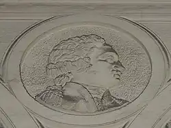 Bas-relief, la tête d'un homme de profil.