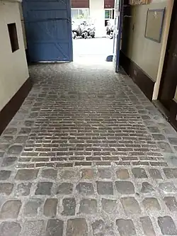 Les pavés en bois visibles dans les rectangles centraux sous le porche du passage.