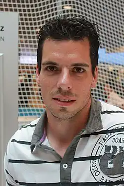 Portrait d’un homme de face, portant un polo. Photographie en couleur