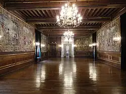 Photographie en couleurs d'une grande salle avec une statue blanche en fond.