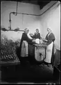 Trois femmes affairées à la friture des sardines dans une conserverie de Douarnenez, au début du XXe siècle